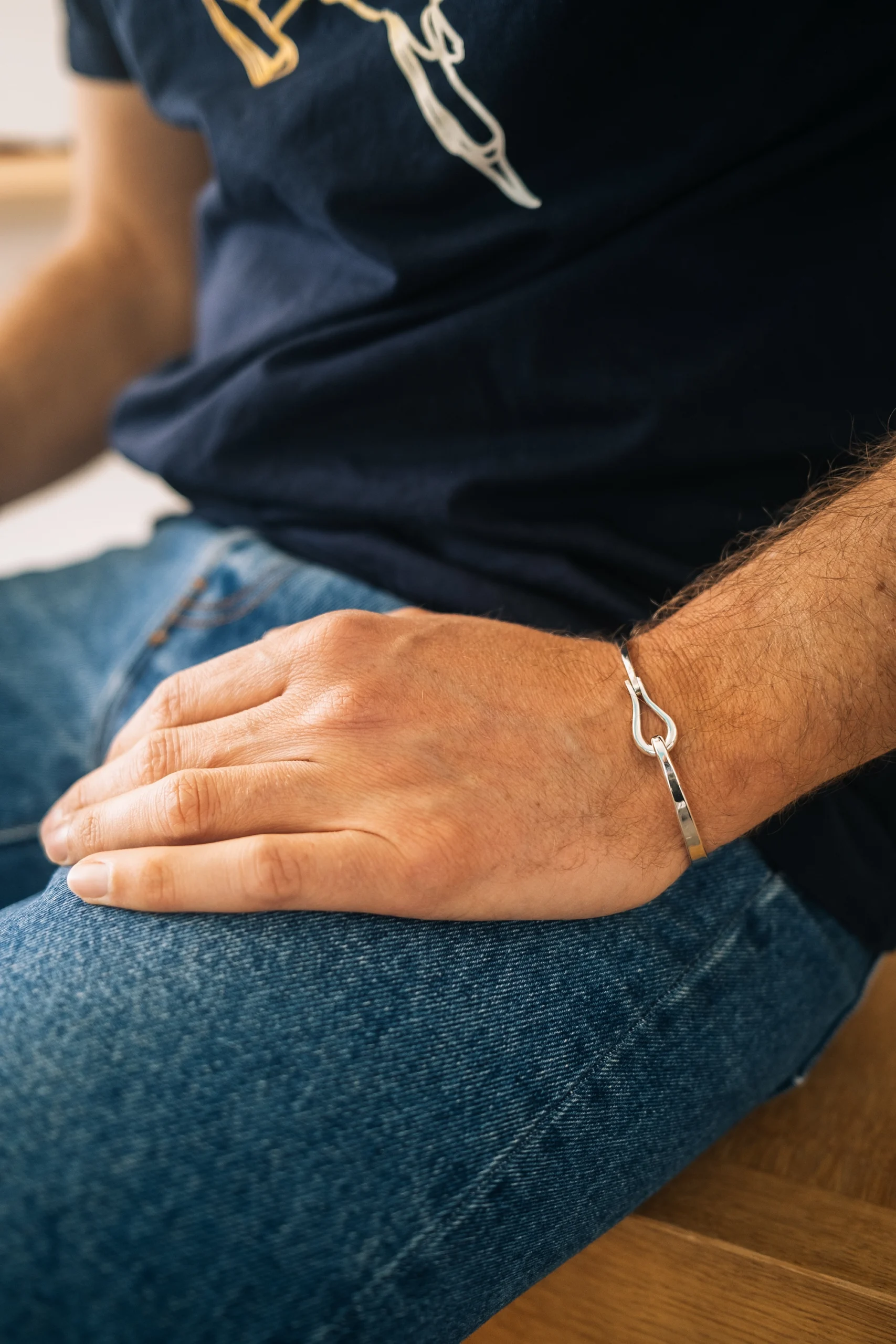 Main d’un homme portant un bracelet Adrien Moniquet en situation dans l’atelier
