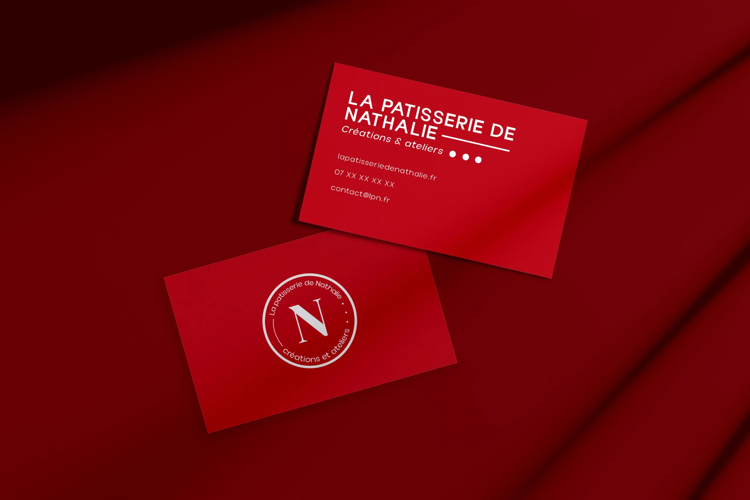 Cartes de visite rouges de La Patisserie de Nathalie avec logo circulaire embossé
