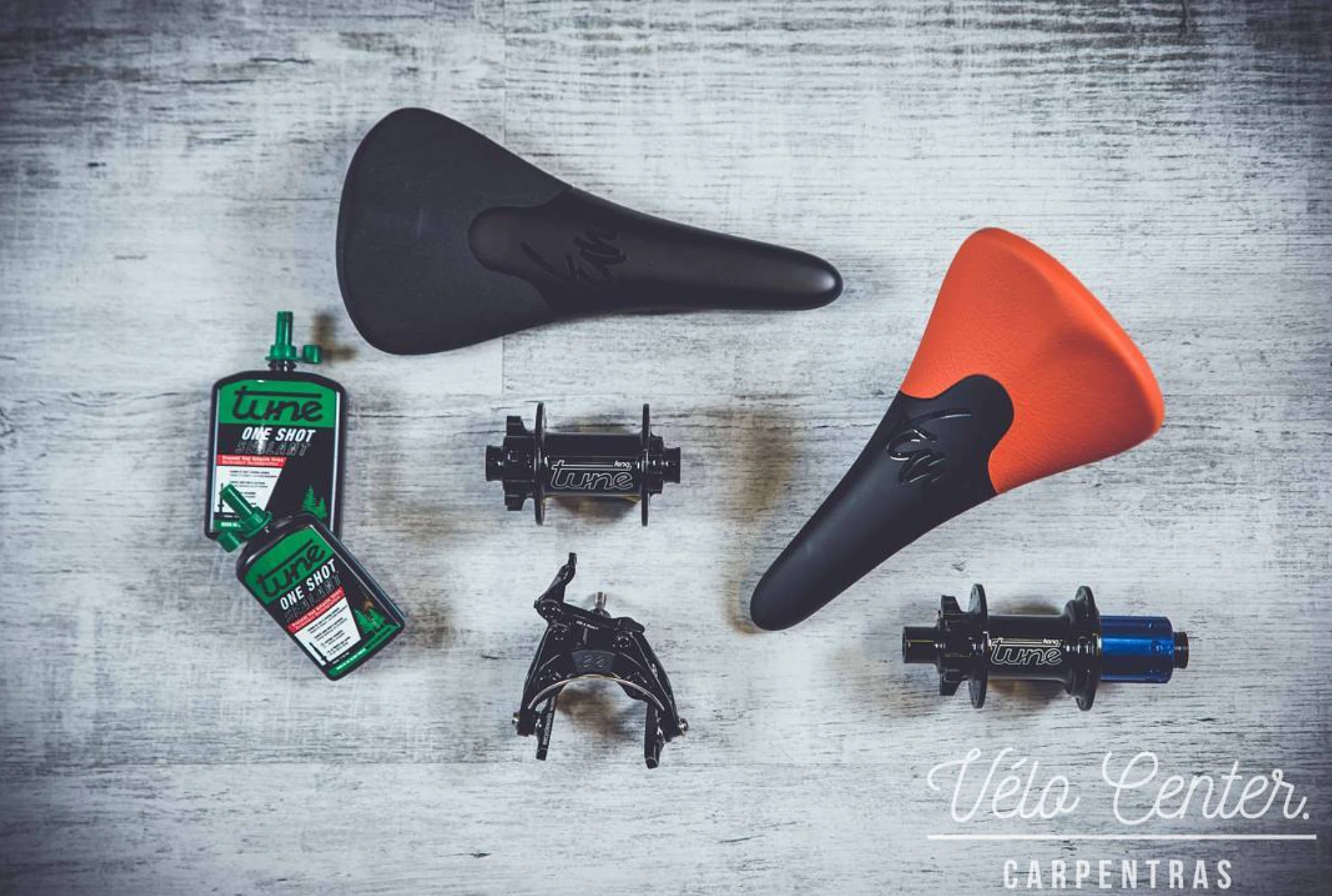 Selle, pédales automatiques et outils vélo route disposés à plat dans l’atelier de Vélo Center Carpentras