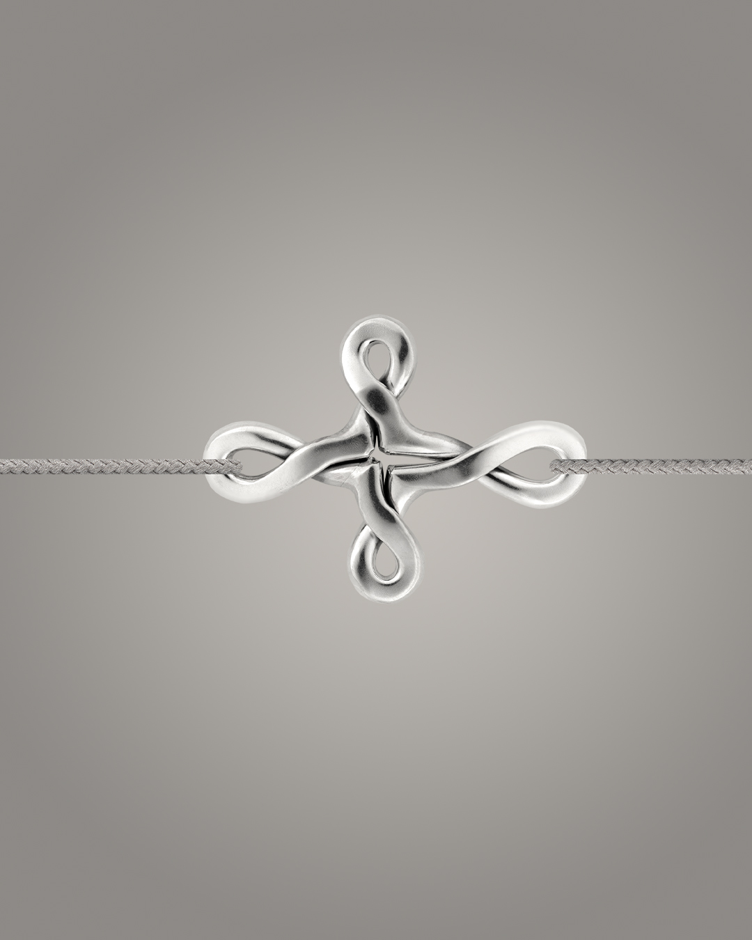 Bracelet en argent en forme de nœud croisé, design Cordon Lisette – photographie studio sur fond gris