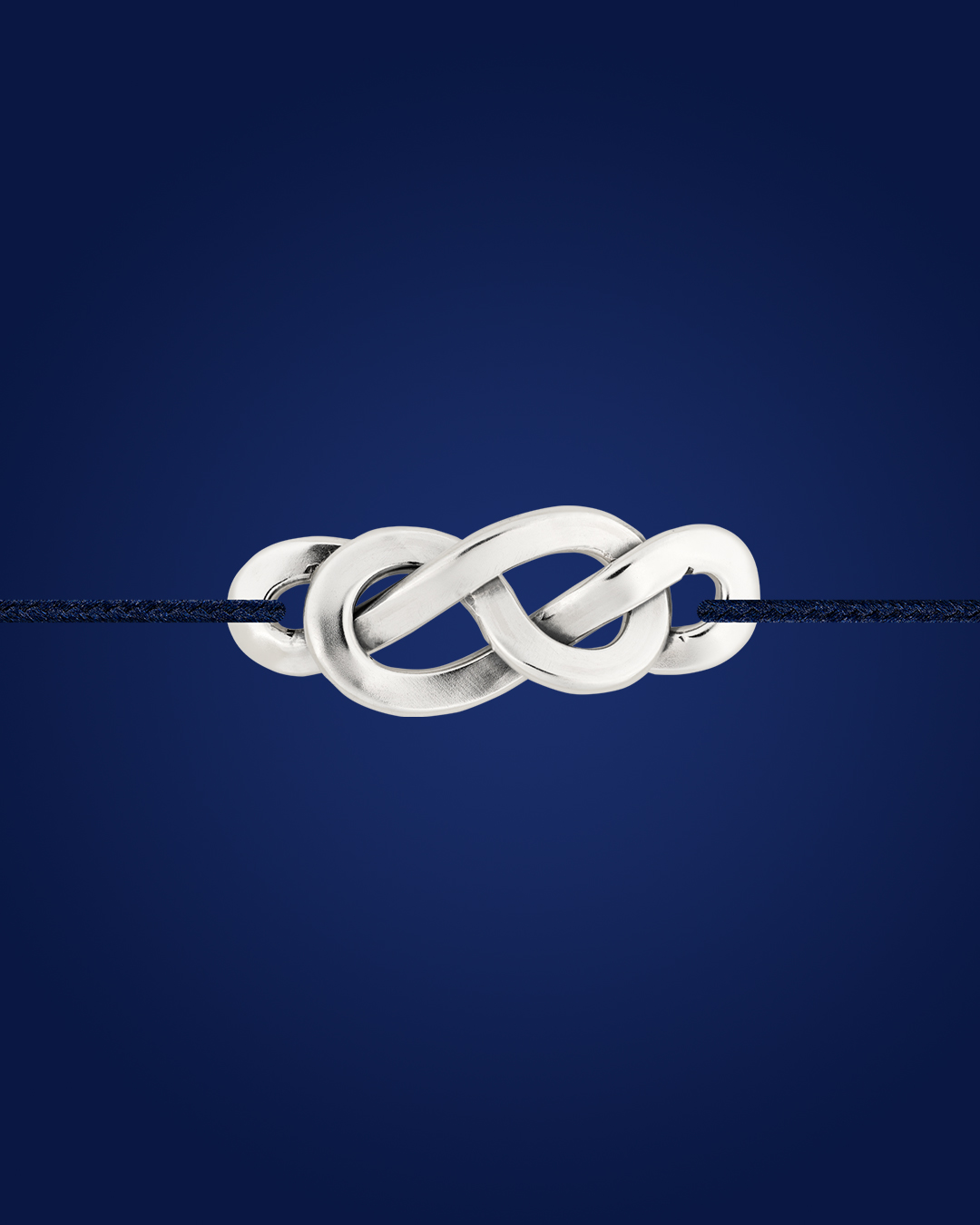 Bracelet en argent tressé façon cordon de Savoie, sur fond bleu – packshot studio Adrien Moniquet