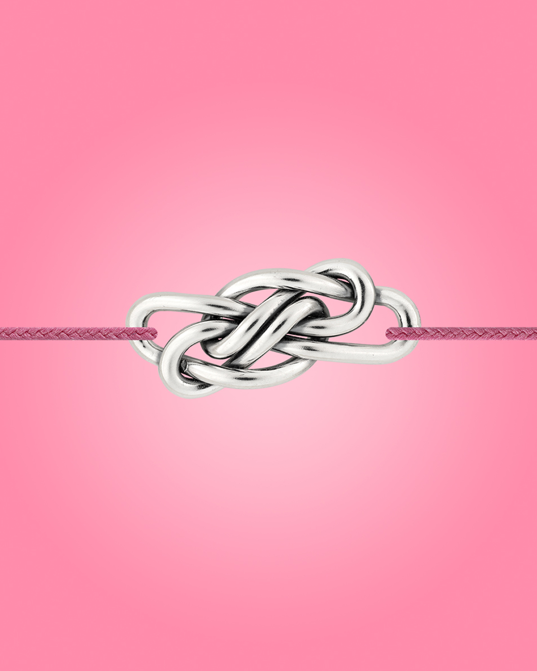Bracelet en argent noué présenté sur fond rose, collection Adrien Moniquet
