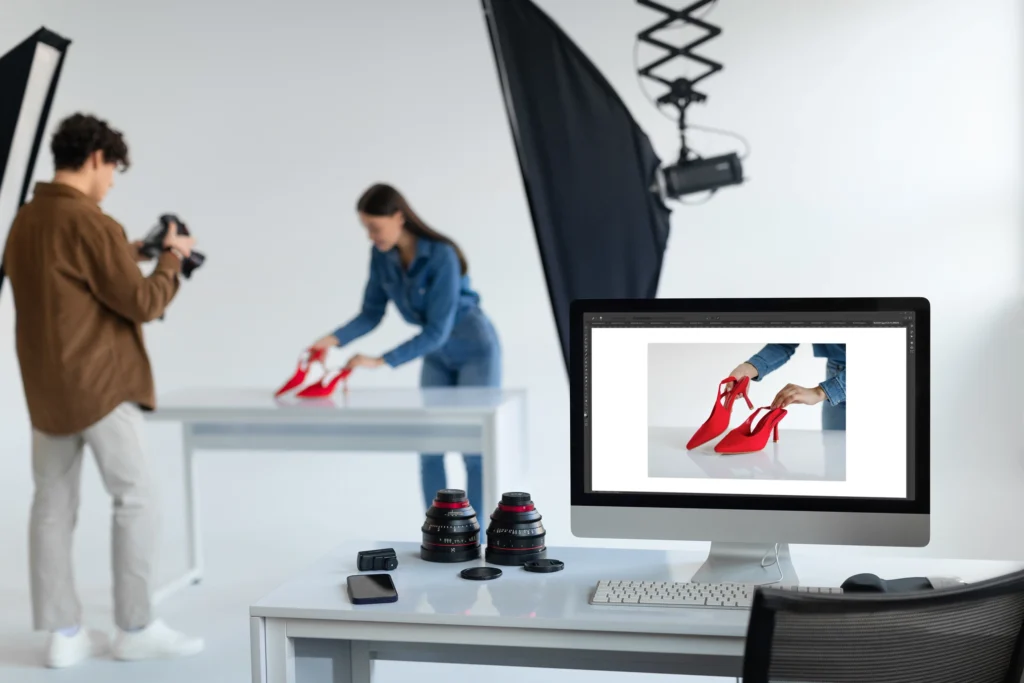 Photographe professionnel réalisant un packshot produit assisté par un technicien dans un studio photo moderne