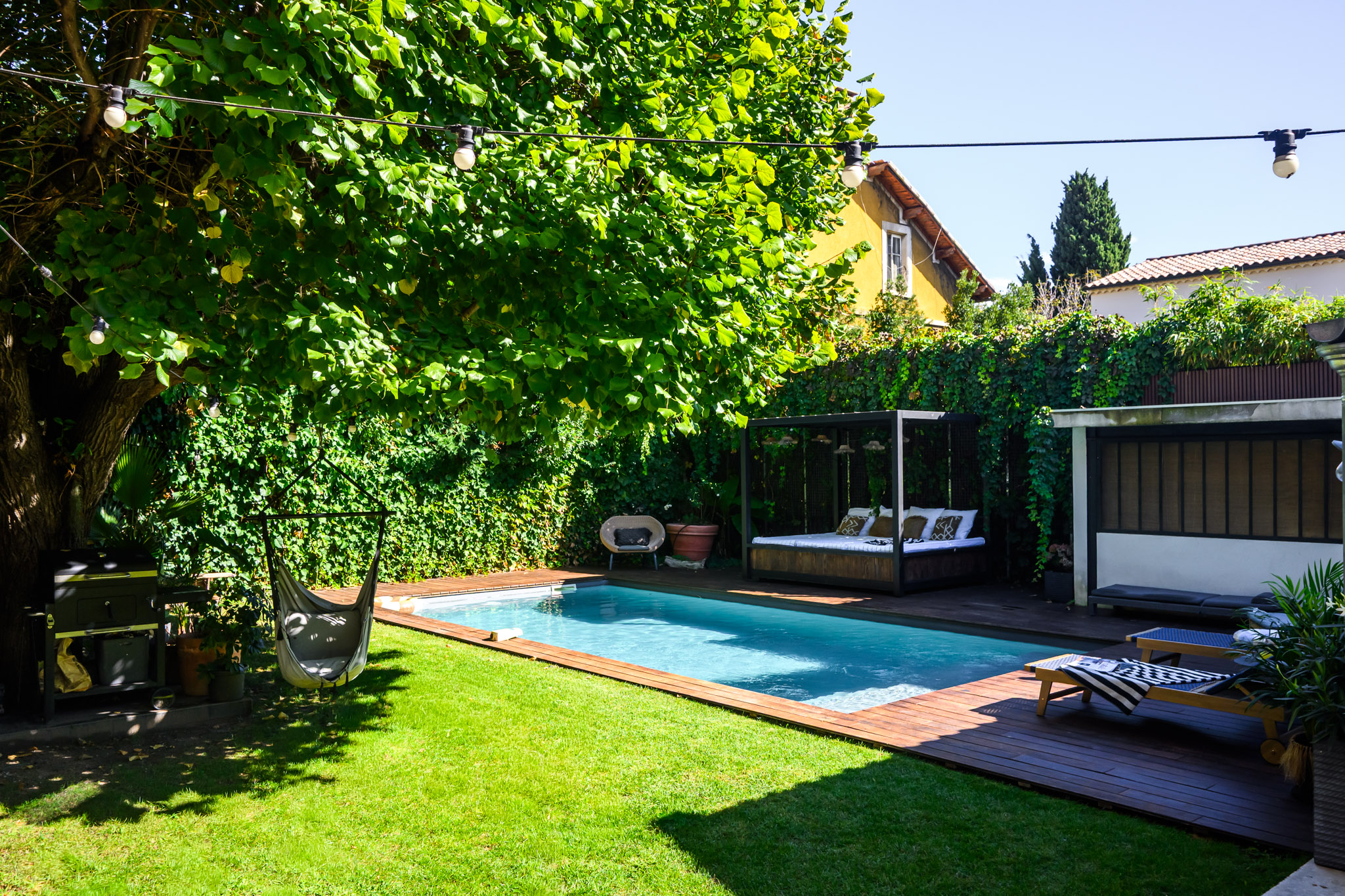 Jardin du loft de Carpentras avec piscine, terrasse en bois et verdure