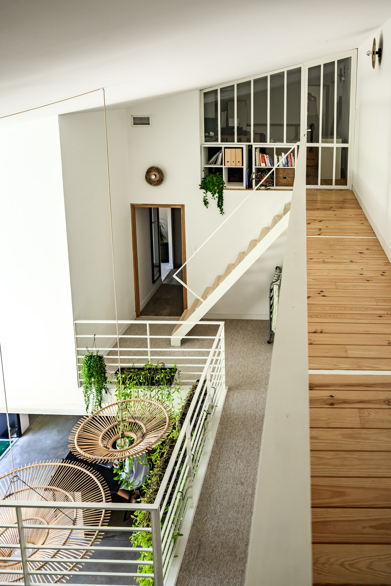 Couloir du loft de Carpentras avec parquet bois, garde-corps métal et grandes baies vitrées