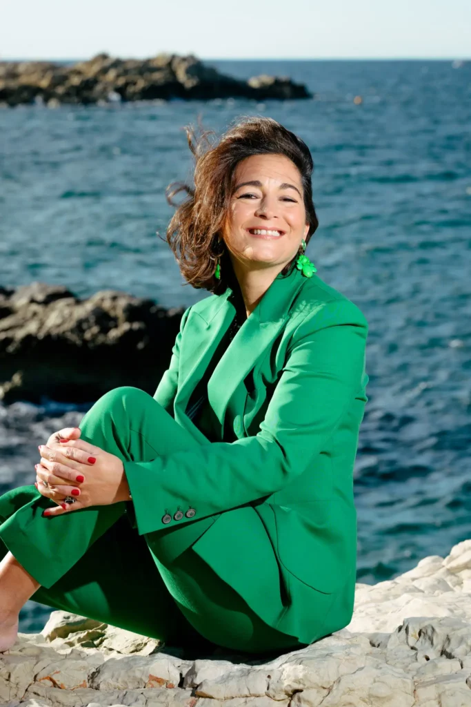Portrait mode en tailleur vert sur les rochers à Malmousque face à la mer.