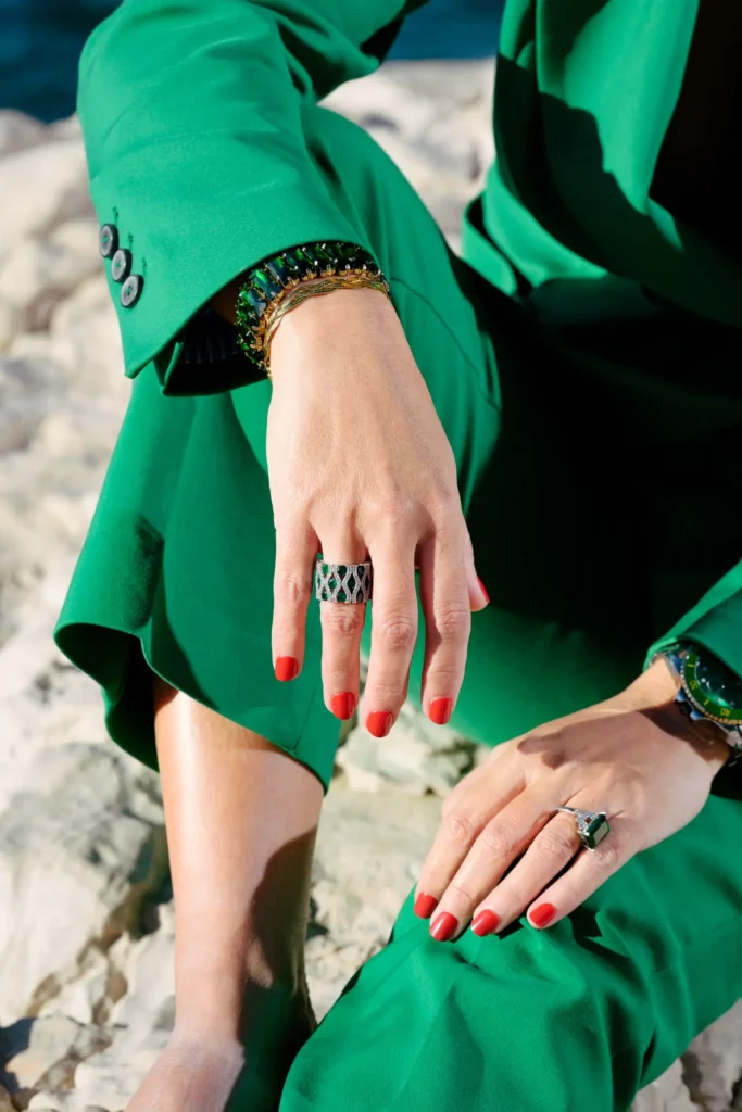 Détails mode lookbook avec tailleur vert et bijoux assortis à Malmousque sur rochers.