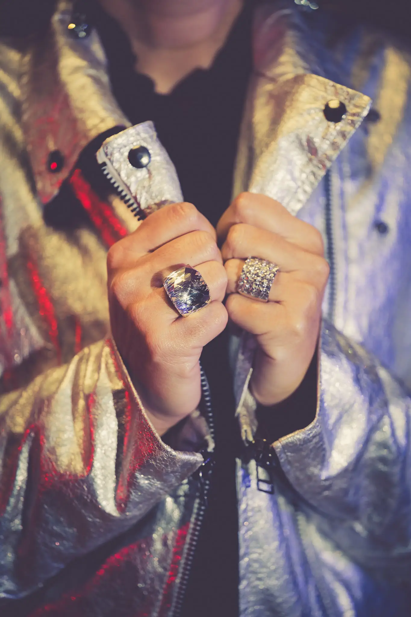 Détail fashion de bijoux argentés avec veste métallisée dans un lookbook rétro futuriste.